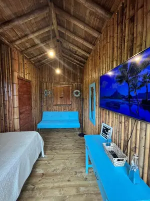 a room with two beds and a tv on the wall at Glamping Caribe con bar y bañera privada in Sopetran