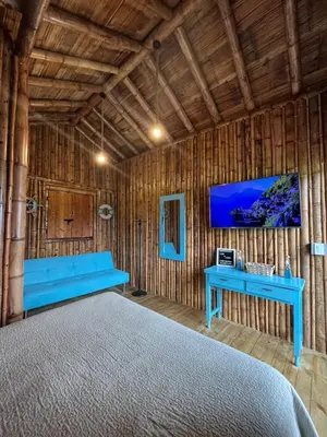 a bedroom with a blue bench and a tv on a wall at Glamping Caribe con bar y bañera privada in Sopetran
