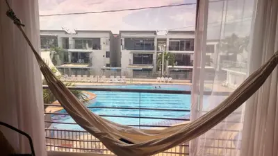 a hammock in front of a window with a pool at Apartasol Familiar 2 in Santa Fe de Antioquia