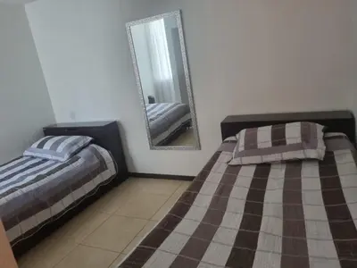 a bedroom with two beds and a mirror at Apartasol Familiar 2 in Santa Fe de Antioquia