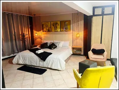 a bedroom with a large bed and a chair at HOTEL VILLA ROSa in Medellín