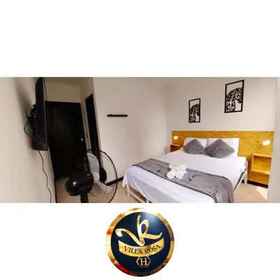a bedroom with a bed and a flat screen tv at HOTEL VILLA ROSa in Medellín