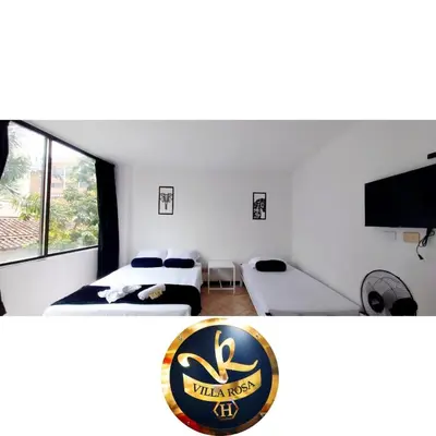 a hotel room with two beds and a tv at HOTEL VILLA ROSa in Medellín