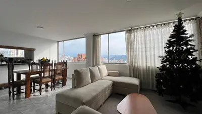 a living room with a christmas tree in front of a table at Apartamento 3 habitaciones 2 baños Vista Panoramica - Av Santander Sector El Cable y Estadio Palogrande in Manizales