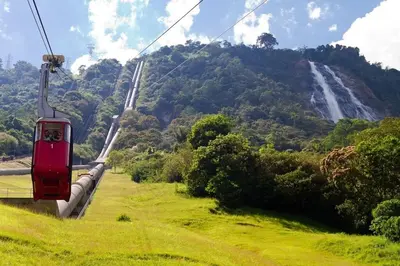 a red cable car with a waterfall in the background at Villa Manantiales con baño turco y Jaquzzi in Carolina del Principe