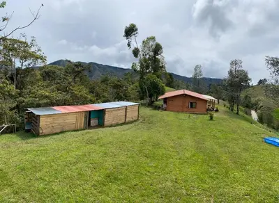 a small building in a field with a house at Villa Manantiales con baño turco y Jaquzzi in Carolina del Principe
