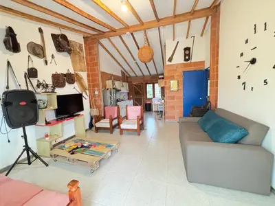 a living room with a couch and a clock on the wall at Villa Manantiales con baño turco y Jaquzzi in Carolina del Principe