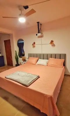 a bedroom with a large bed with orange sheets at OSIMiRI JAMAICA Ríos cristalinos, naturaleza y tranquilidad in San Rafael