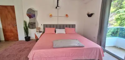 a bedroom with a large bed with pink sheets at OSIMiRI JAMAICA Ríos cristalinos, naturaleza y tranquilidad in San Rafael