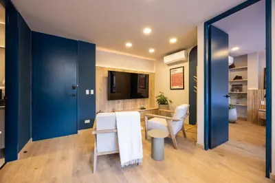 a dining room with blue walls and a table and chairs at StrataSix Hotel in Medellín