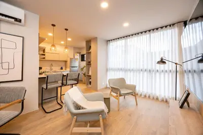 a living room with chairs and a dining room at StrataSix Hotel in Medellín