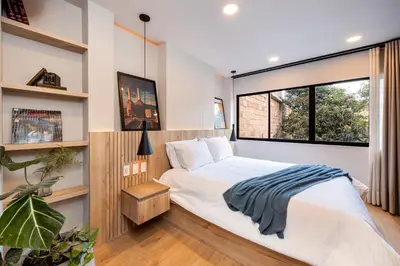 a bedroom with a bed and a large window at StrataSix Hotel in Medellín