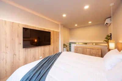 a bedroom with a large bed with a tv on the wall at StrataSix Hotel in Medellín