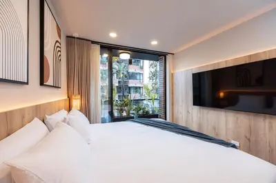 a bedroom with a white bed and a large window at StrataSix Hotel in Medellín