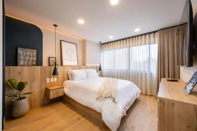 a bedroom with a large bed and a window at StrataSix Hotel in Medellín