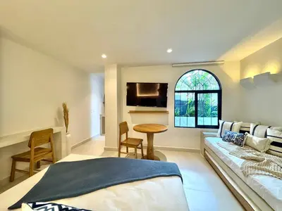 a bedroom with a bed and a couch and a table at Villa kalah in Puerto Triunfo