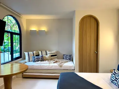 a bedroom with a bed and a table and a window at Villa kalah in Puerto Triunfo