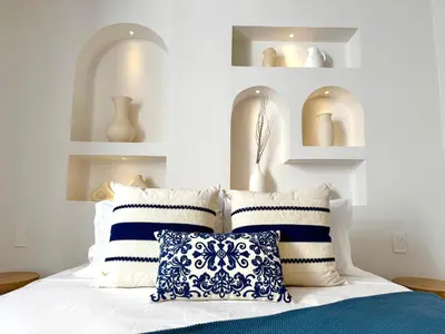 a bedroom with a bed with blue and white pillows at Villa kalah in Puerto Triunfo