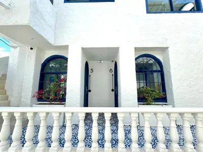 a white house with a white door and two windows at Villa kalah in Puerto Triunfo
