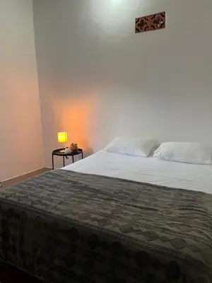 a bedroom with a bed and a table with a lamp at Casa Blue Jericó in Jericó