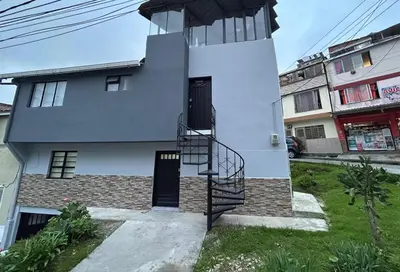 a white house with a spiral staircase in front of it at Apartamento en Manizales in Manizales
