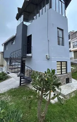 a white house with a tree in front of it at Apartamento en Manizales in Manizales