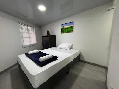 a small bedroom with a bed with a blue blanket at Apartamento en Manizales in Manizales