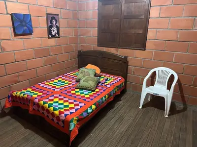 a bedroom with a bed and a chair at Paraiso del Nomada in Barbosa