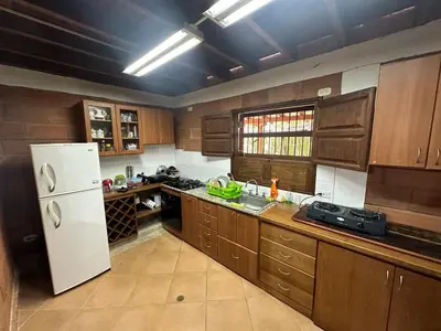 a kitchen with wooden cabinets and a white refrigerator at Paraiso del Nomada in Barbosa