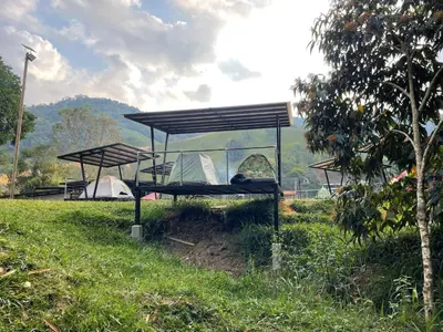 two picnic tables in a field with a tent at Santa María del Río in San Rafael
