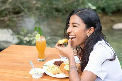 a woman sitting at a table eating a plate of food at Santa María del Río in San Rafael