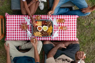 a group of people sitting at a picnic table with food at Santa María del Río in San Rafael