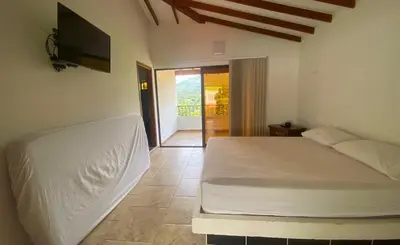 a bedroom with a bed and a flat screen tv at Chalets Villa Marina in Copacabana