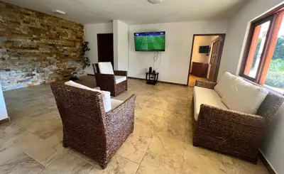 a living room with wicker chairs and a tv at Chalets Villa Marina in Copacabana