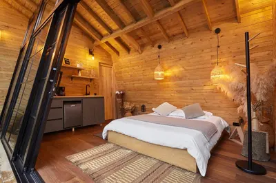 a bedroom with a bed and a wooden wall at Onirico Refugio in Medellín