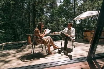 a man and a woman sitting at a table on a deck at Onirico Refugio in Medellín