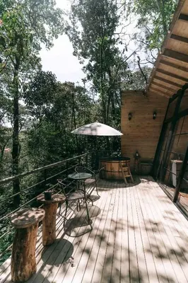 a wooden deck with a table and an umbrella at Onirico Refugio in Medellín