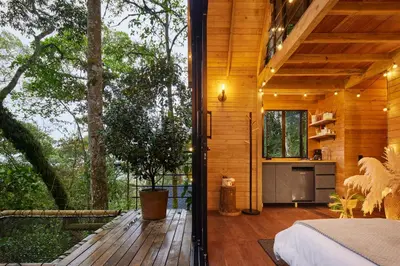 a wooden house with a kitchen and a deck at Onirico Refugio in Medellín