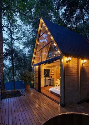 a small house with a bed on a wooden deck at Onirico Refugio in Medellín
