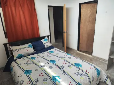 a bedroom with a bed with a colorful comforter at Spacious and calm place to stay in Santa Fe de Antioquia