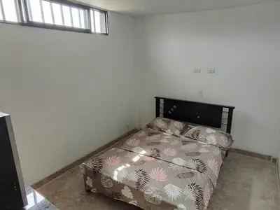 a bedroom with a bed in the corner of a room at Spacious and calm place to stay in Santa Fe de Antioquia