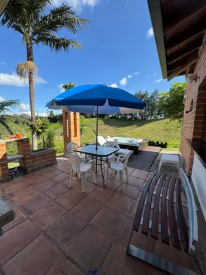 a patio with a table and chairs and an umbrella at Finca Villa Palmeras en Rionegro Aeropuerto JMC in Rionegro