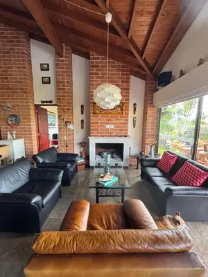 a living room with leather furniture and a brick wall at Finca Villa Palmeras en Rionegro Aeropuerto JMC in Rionegro