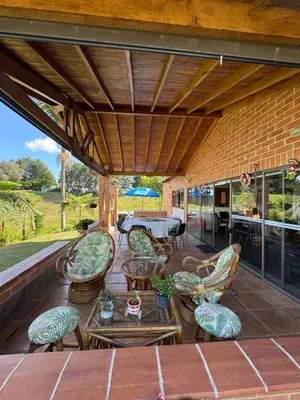 an outdoor patio with chairs and a table at Finca Villa Palmeras en Rionegro Aeropuerto JMC in Rionegro