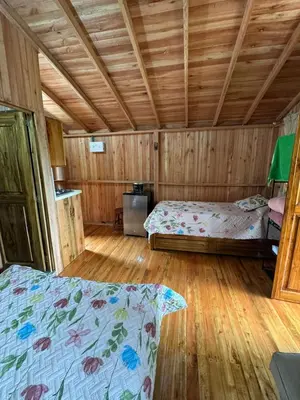 a bedroom with two beds in a wooden cabin at Cabaña octaluz in Jardin
