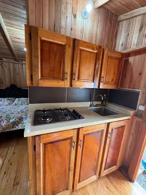 a kitchen with wooden cabinets and a stove top oven at Cabaña octaluz in Jardin