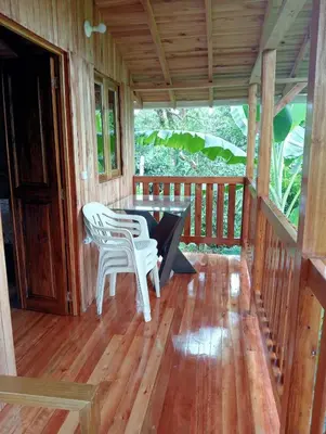 a porch with two chairs and a table on it at Cabaña octaluz in Jardin