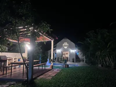 a backyard at night with a bench and a house at Cabaña G203 in Girardota