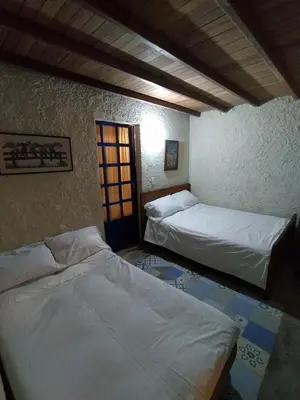 a room with two beds in a room with a window at Cabaña G203 in Girardota