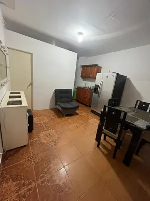 a kitchen with a table and a chair and a refrigerator at Apartamento Amoblado en Doradal in Las Mercedes